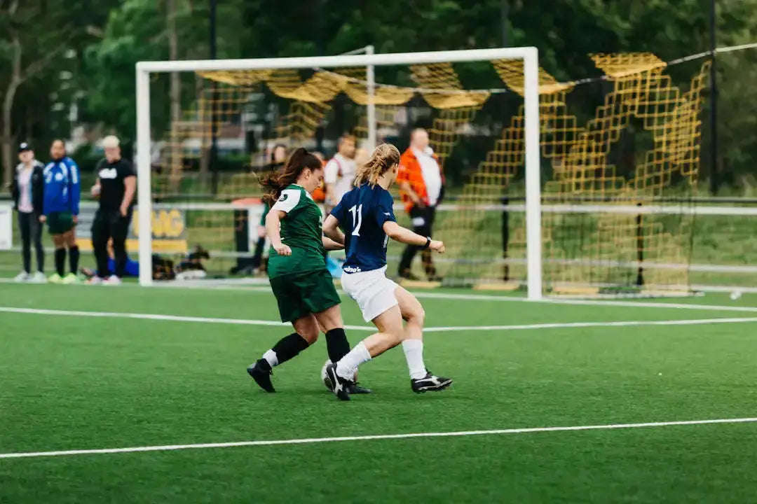 Two empowered female soccer players in action on green field