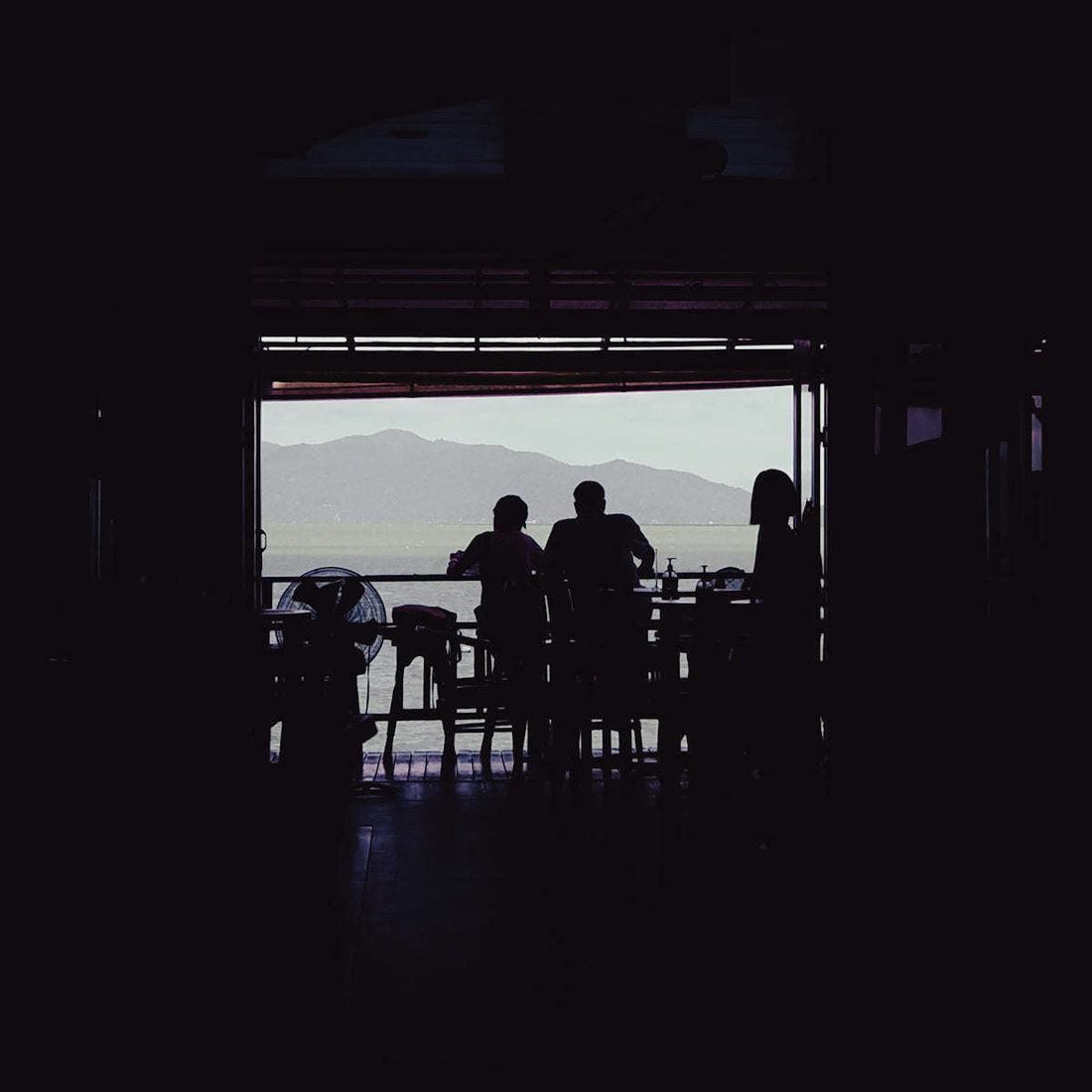 a group of people sitting at a table in front of a window