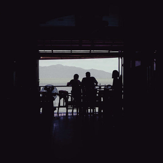 a group of people sitting at a table in front of a window