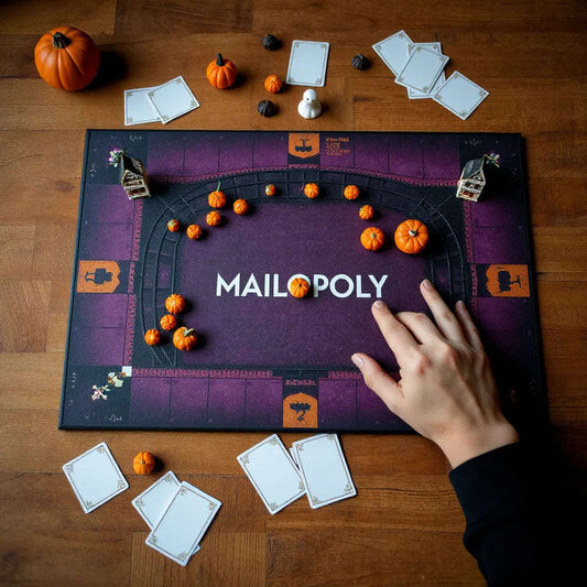 Monopoly-style board game on a dark tabletop with themed properties and tokens ready to move