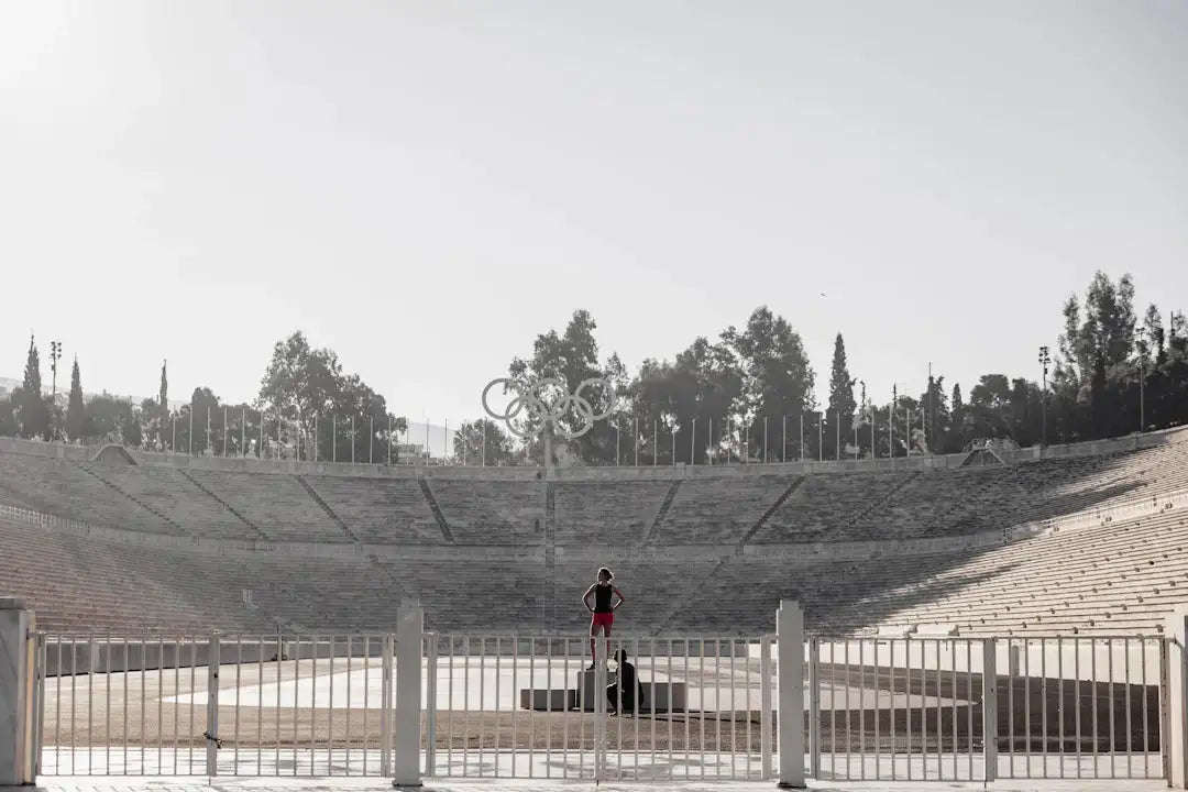 Reflective metallic Olympic rings monument in sports evolution history