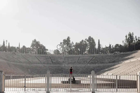Reflective metallic Olympic rings monument in sports evolution history